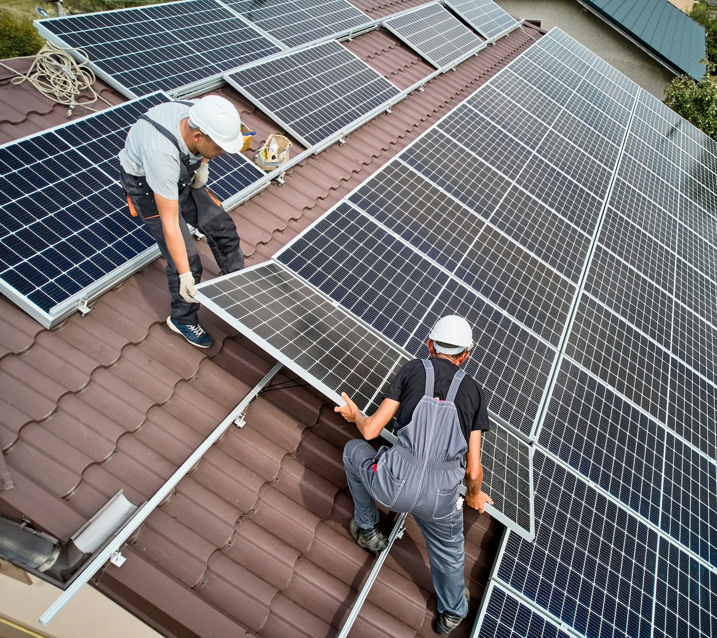 Due installatori stanno installando pannelli fotovoltaici su un tetto